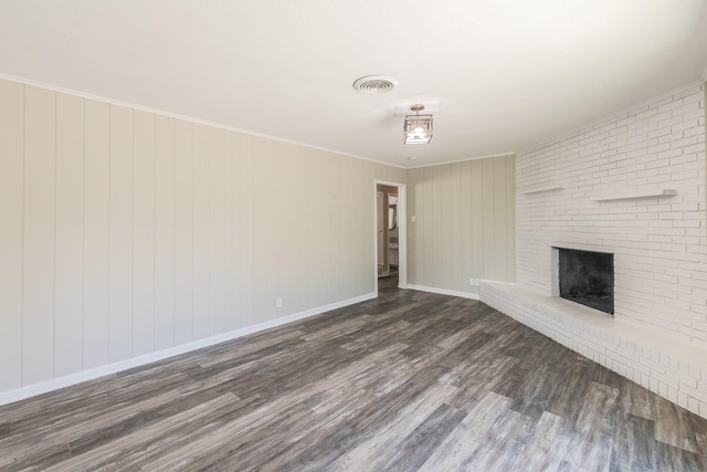 unfurnished living room featuring dark wood-type flooring, crown molding, and a fireplace