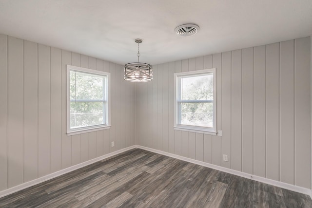 empty room featuring dark hardwood / wood-style floors and a notable chandelier