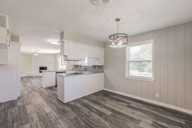 kitchen with a notable chandelier, white cabinetry, kitchen peninsula, and decorative light fixtures