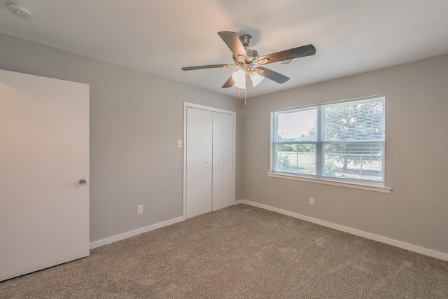 unfurnished bedroom featuring ceiling fan, a closet, and carpet floors