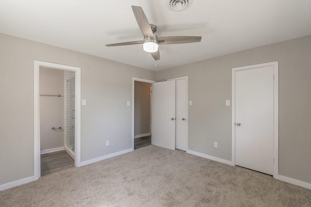 unfurnished bedroom with ceiling fan, light colored carpet, and ensuite bathroom