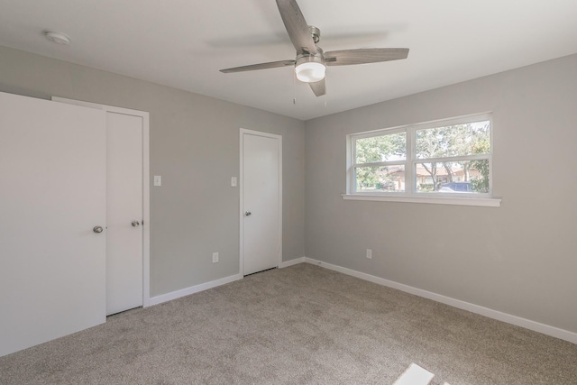 unfurnished bedroom with ceiling fan, light colored carpet, and a closet