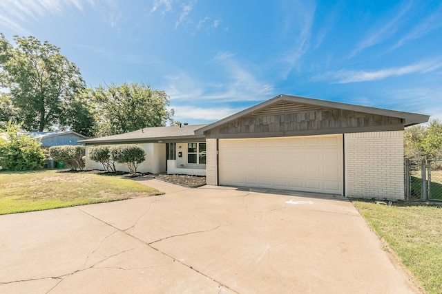 single story home featuring a front lawn and a garage