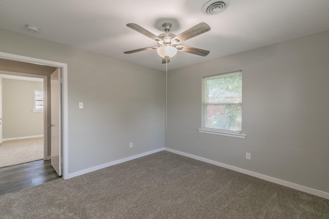 spare room featuring ceiling fan and dark carpet