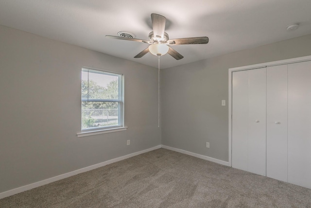 unfurnished bedroom with ceiling fan, a closet, and carpet