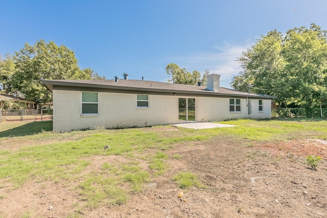 rear view of house with a lawn and a patio