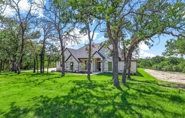 view of front of house featuring stone siding and a front lawn