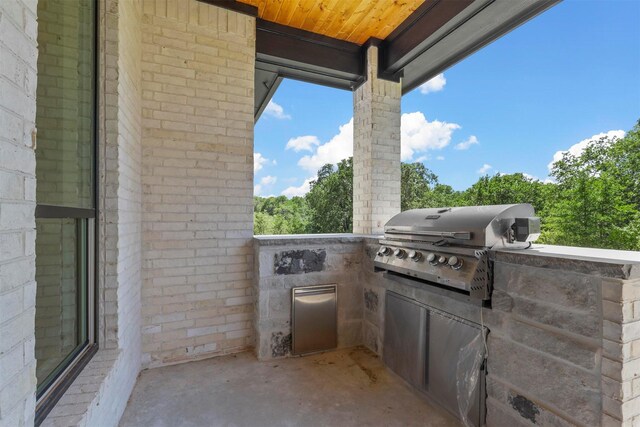 view of patio / terrace with grilling area, an outdoor stone fireplace, and an outdoor kitchen