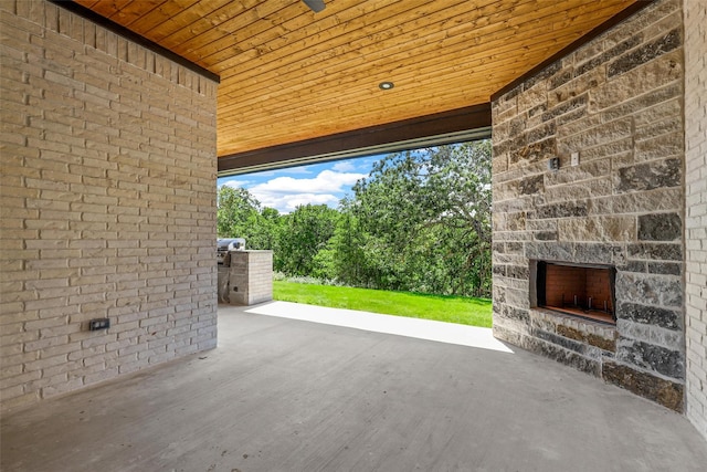 view of patio / terrace with an outdoor stone fireplace and area for grilling