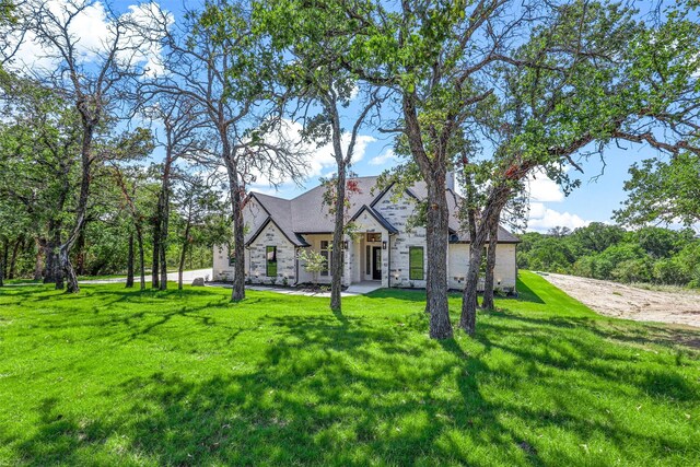 unfurnished room with light wood-type flooring, french doors, and a stone fireplace