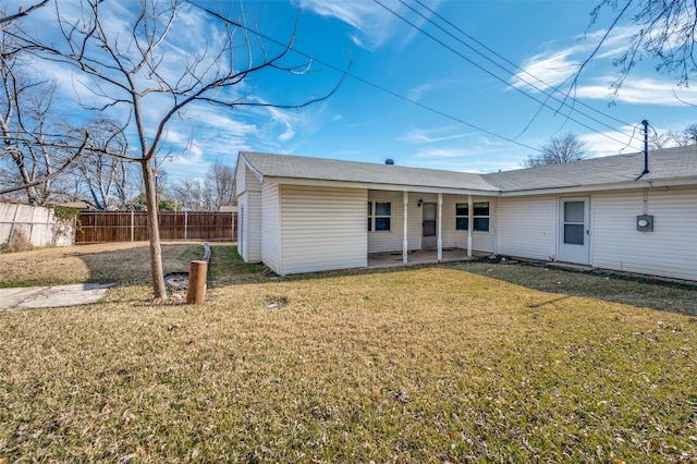 rear view of property featuring a lawn