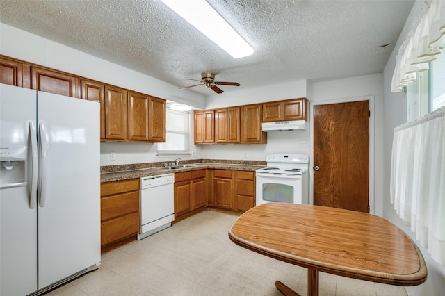 kitchen with ceiling fan, sink, white appliances, and a textured ceiling