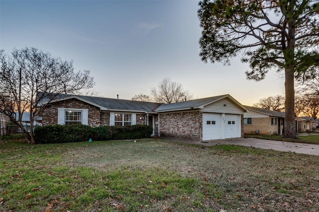 single story home with a garage and a lawn