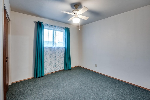 unfurnished room with ceiling fan and dark carpet