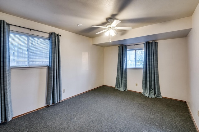 unfurnished room with ceiling fan and dark carpet