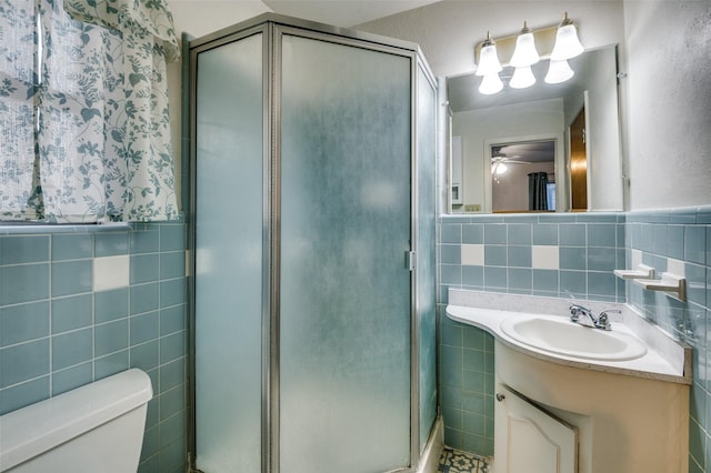 bathroom with an enclosed shower, vanity, and tile walls