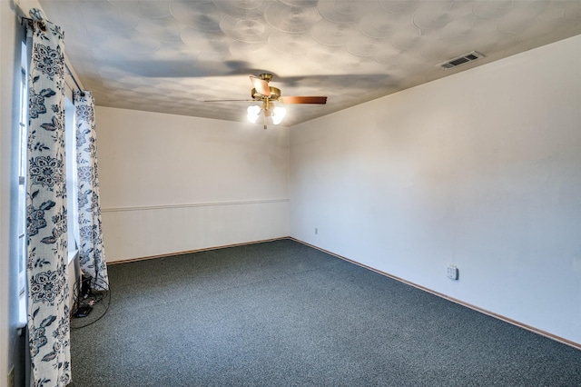 spare room featuring ceiling fan and carpet