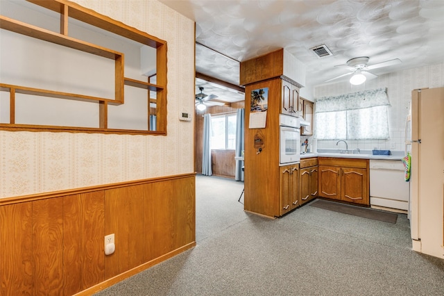 kitchen featuring ceiling fan, sink, light colored carpet, and white appliances