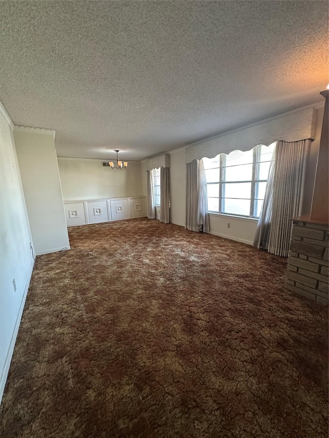 unfurnished living room featuring a textured ceiling, carpet flooring, and a notable chandelier