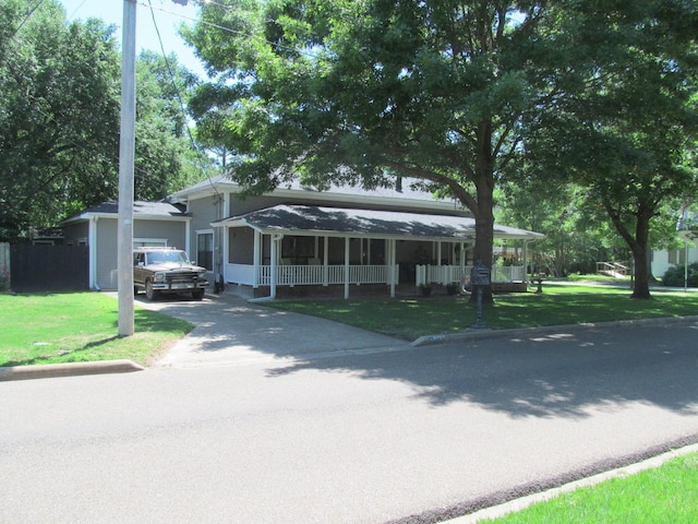 view of front of home with a front lawn, covered porch, and a garage