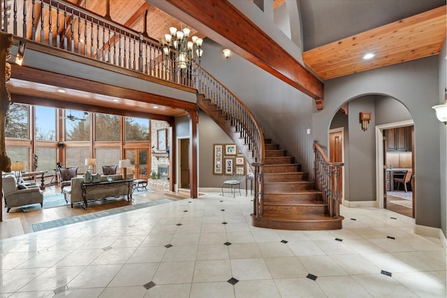 interior space with an inviting chandelier, tile patterned flooring, and a towering ceiling