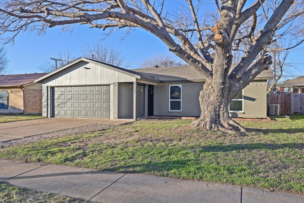 ranch-style house with a garage, a front yard, and central air condition unit