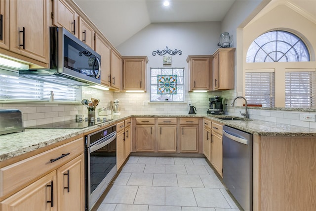 kitchen featuring lofted ceiling, decorative backsplash, sink, stainless steel appliances, and light tile patterned floors