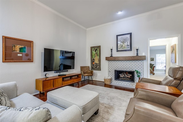 living room with hardwood / wood-style floors, a tile fireplace, and crown molding