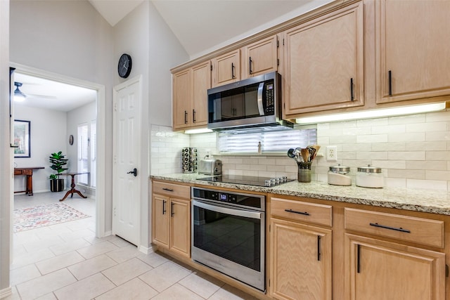 kitchen with light tile patterned floors, stainless steel appliances, decorative backsplash, light stone countertops, and vaulted ceiling