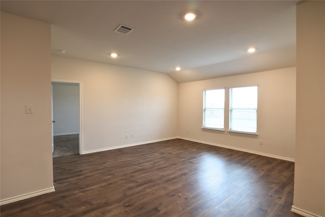 unfurnished room with lofted ceiling, visible vents, dark wood finished floors, and recessed lighting