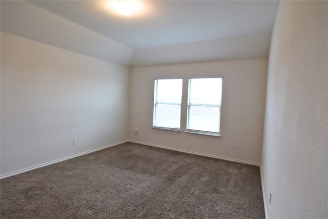 unfurnished room with dark carpet and baseboards