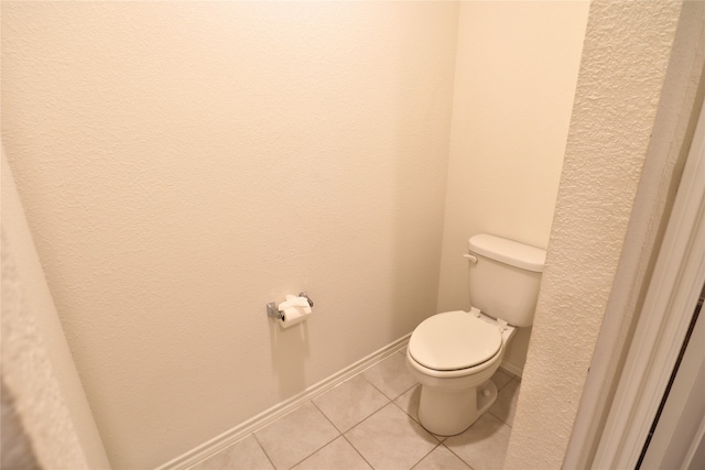 bathroom featuring baseboards, toilet, and tile patterned floors