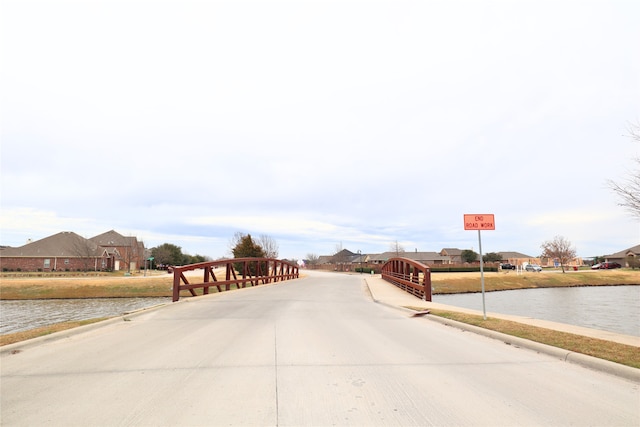 view of road with a residential view and a water view