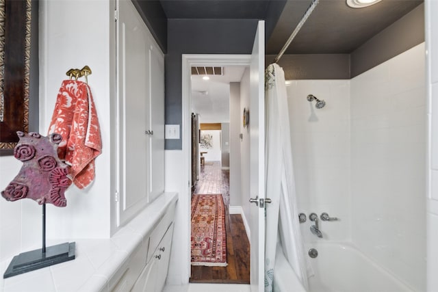 bathroom with wood-type flooring and shower / bath combo with shower curtain