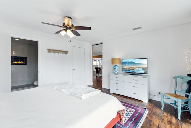 bedroom featuring ceiling fan, dark hardwood / wood-style floors, and ensuite bath