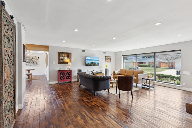 living room with dark wood-type flooring and a barn door