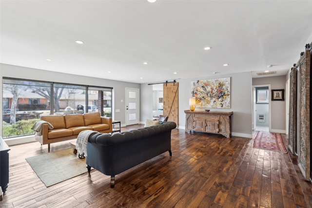 living room with dark hardwood / wood-style flooring and a barn door