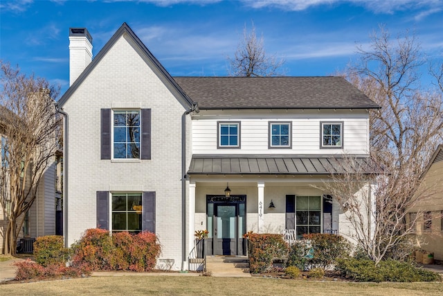 view of front of home with a front yard and central AC