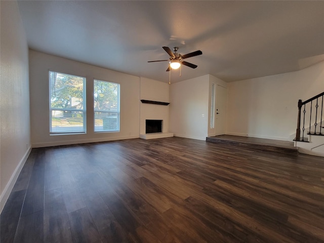 unfurnished living room featuring ceiling fan and dark hardwood / wood-style floors