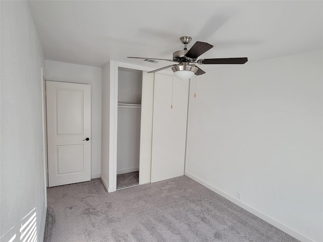 unfurnished bedroom featuring light carpet, ceiling fan, and a closet