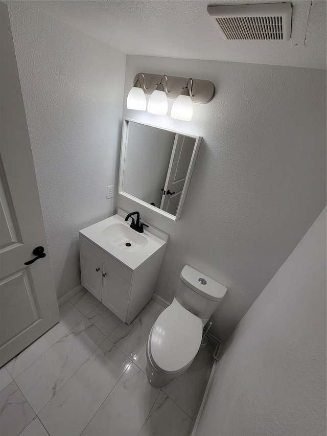 bathroom featuring toilet and vanity