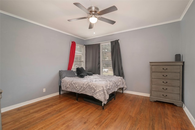 bedroom featuring ceiling fan, wood-type flooring, and crown molding