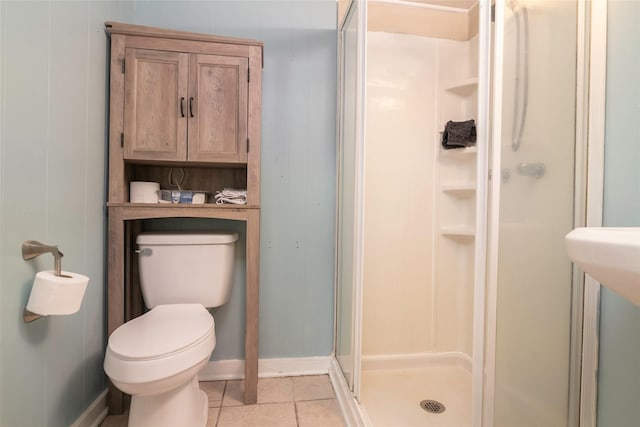 bathroom featuring toilet, tile patterned floors, and a shower with shower door