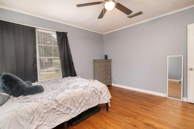 bedroom featuring ceiling fan, hardwood / wood-style floors, and crown molding