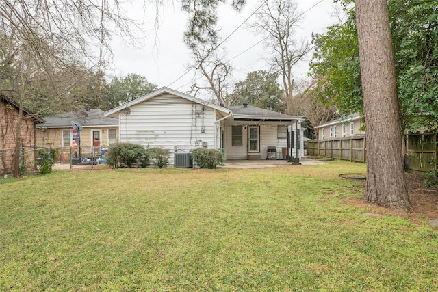 rear view of property with a patio area, central air condition unit, and a lawn