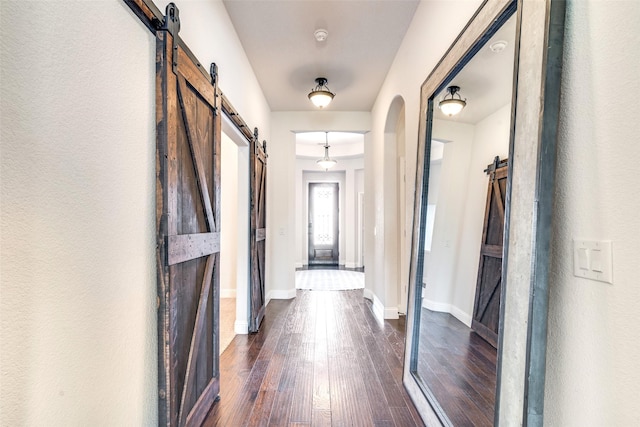 hall featuring dark hardwood / wood-style floors and a barn door