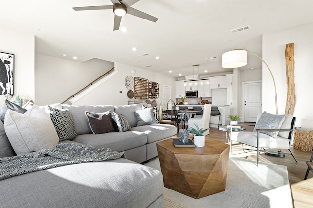 living room featuring light wood-type flooring, sink, and ceiling fan