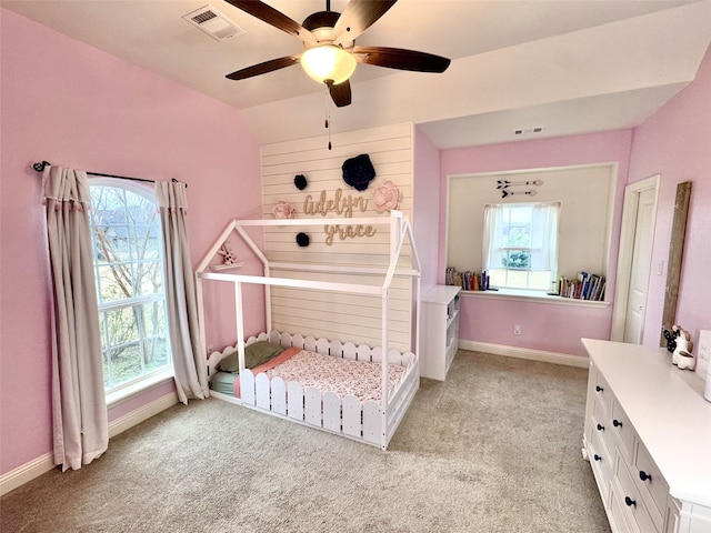 bedroom featuring ceiling fan, light colored carpet, and multiple windows