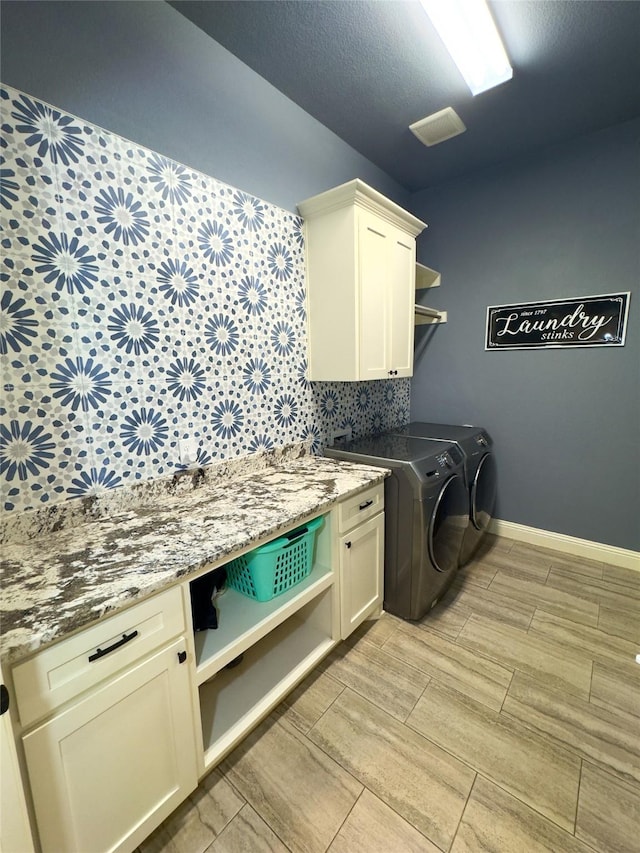 laundry area featuring washing machine and dryer and cabinets