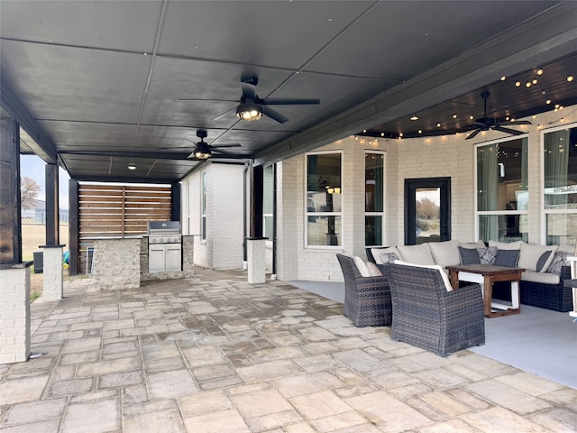 view of patio with ceiling fan, exterior kitchen, an outdoor living space, and grilling area